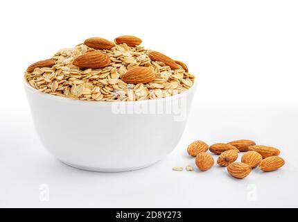 Oatmeal breakfast with almond nuts in bowl isolated on white background. Healthy food concept Stock Photo