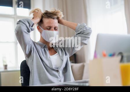 Woman indoors in office feeling stressed, mental health and coronavirus concept. Stock Photo