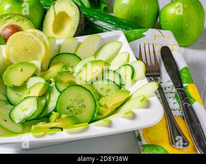 Healthy green fruit vegetable salad with avocados, cucumbers and apples served sliced in a big white bowl Stock Photo