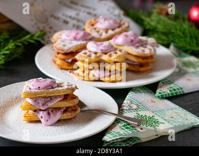 Christmas waffle dessert with cream filling. heart shaped on a plate. Selective focus, shallow depth of field Stock Photo