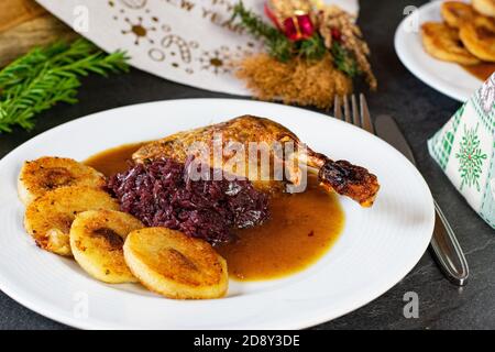 delicious plate with a christmas dinner. roasted duck leg with red cabbage and fried potato dumplings Stock Photo
