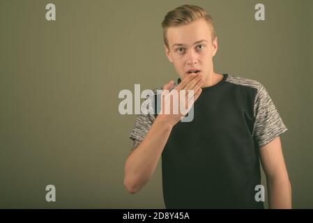 Young handsome man with blond hair against colored background Stock Photo