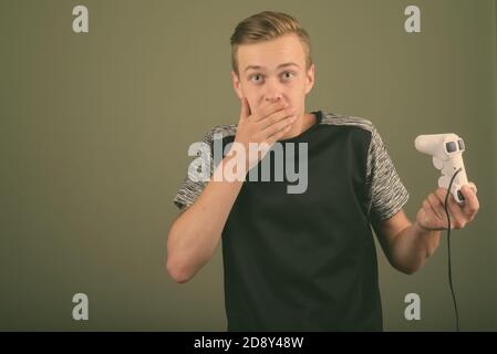 Young handsome man with blond hair against colored background Stock Photo