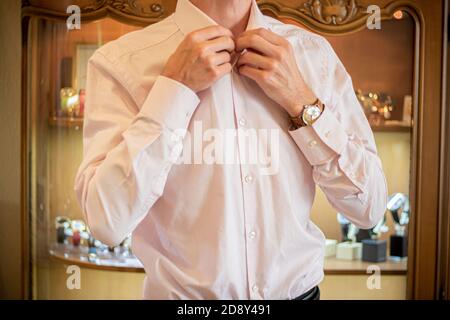 Closeup of a young businessman fixing up his sleeve and looking sharp with watches on hand. Stock Photo