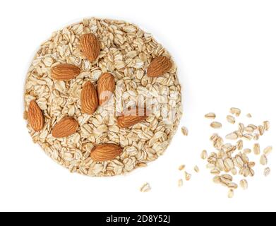 Oatflakes in a bowl  isolated on white background. Pile of oatmeal with almond nuts  top view. Macro Stock Photo