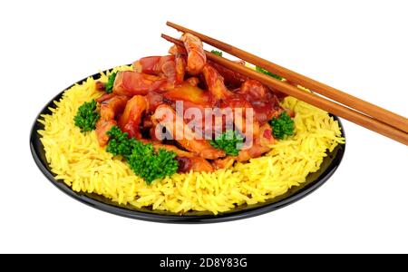 Chinese sweet and sour pork with rice on a black plate isolated on a white background Stock Photo