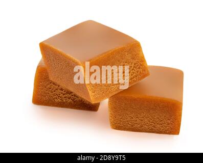 Caramel candy with caramel sauce isolated on a white background close up.  Three pieces of toffee candies Stock Photo