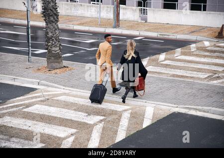High Angle View Of Business Couple Crossing Street On Way To Meeting Stock Photo