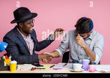 Two colleagues working together, discussing new project, making financial report, holding pens, sitting at office desk, wearing formal wear, glasses, Stock Photo