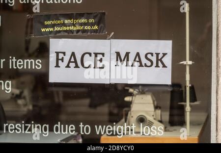 A tailor's window offering a re-sizing service. Obesity has been directly linked to risk of serious health complications when infected by Coronavirus. Stock Photo