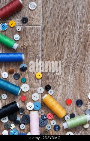 Colored threads and buttons on a background of boards Stock Photo