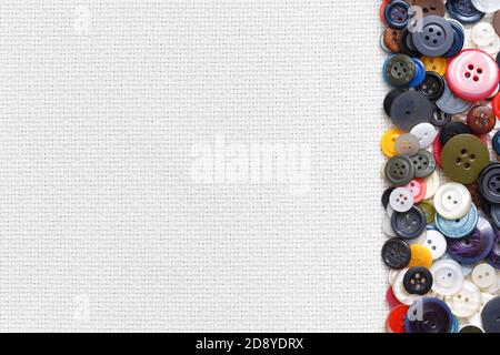 Multi-colored buttons on a white woven background in the form of a frame. Stock Photo