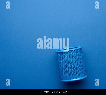 empty iron blue stationery basket for pens and pencils on blue background, copy space Stock Photo