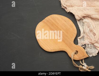 round small cutting board lie on a black background, top view Stock Photo