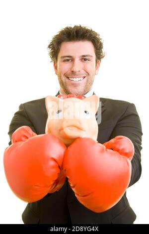 Young man in suit carries a piggy bank on red boxing gloves Stock Photo
