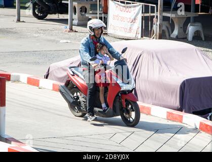 SAMUT PRAKAN, THAILAND, JUL 29 2020, A man ride a motorcycle with a little girl standing on floor. Stock Photo