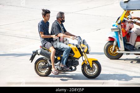 SAMUT PRAKAN, THAILAND, JUL 29 2020, A two men rides on motorcycle at the street. Stock Photo