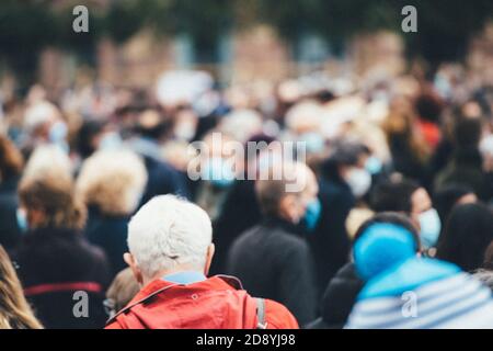 Rear view of people gathering at a protest all of them wearing protective masks due to COVID-19 coronavirus epidemic situation Stock Photo