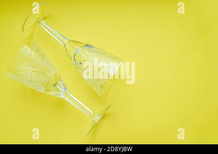 two crystal wine glasses on a yellow background close up Flatlay Stock Photo