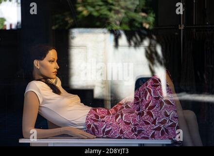 ZURICH, SWITZERLAND, JUL 30 2020, A dressed mannequin of a woman lies behind a shop window. Stock Photo