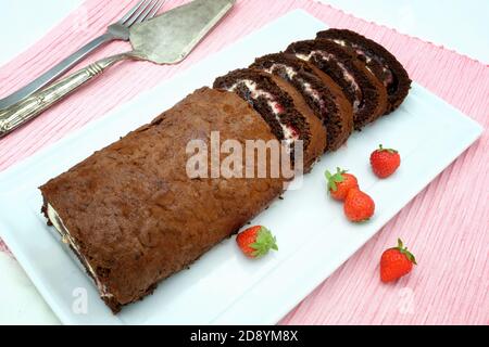 Chocolate, cream and strawberry Swiss roll Stock Photo