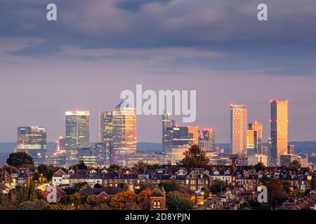 London, urban skyline of docklands commercial district from Muswell Hill. Distant view, illuminated buildings, CBD, downtown, dusk, suburban view Stock Photo