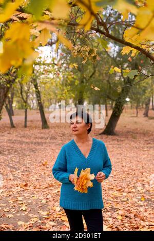 Beautiful caucasian woman walking outdoors in autumn time. Stock Photo