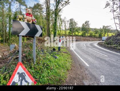 A bend in the road known as Pooh Corner in the Cotswold Hills of Gloucestershire UK with Winnie the Pooh standing on the warning chevrons Stock Photo