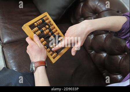 Young male hands hold old wooden abacus Stock Photo