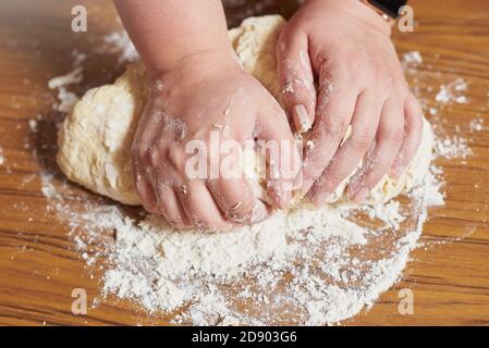 Close up of female hands kneading dough at home Stock Photo
