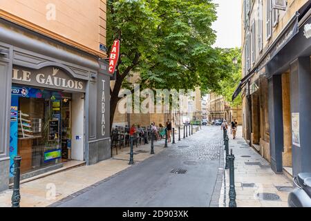 AIX EN PROVENCE, FRANCE - 14.07.19: people enjoy resting at a tree covered place in the old town of charming Aix en Provence. The old roman city