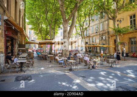 AIX EN PROVENCE, FRANCE - 14.07.19: people enjoy resting at a tree covered place in the old town of charming Aix en Provence. The old roman city Stock Photo