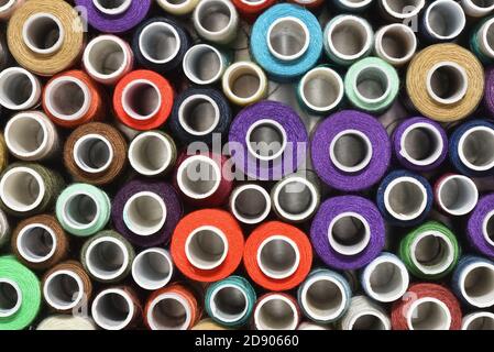 Multicolored sewing thread in spools top view Stock Photo