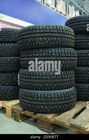 New winter car tires lie on the pallet in a store Stock Photo