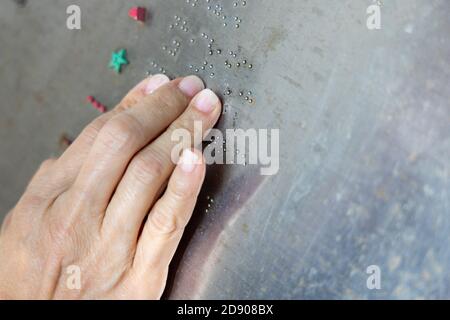 Finger reading braille tactile on public park message board Stock Photo