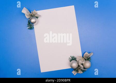 Christmas toys and a blank white sheet of paper. Christmas composition on a blue background Stock Photo