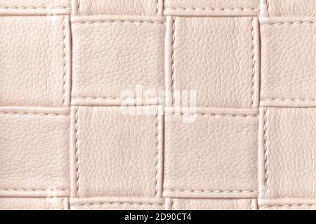 Texture of beige leather background with square pattern and stitch, macro. Abstract backdrop from modern decorative light brown textile with geometric Stock Photo
