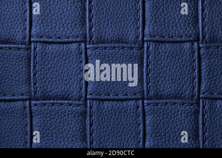Texture of navy blue leather background with square pattern and stitch, macro. Abstract backdrop from modern decorative dark indigo textile with geome Stock Photo