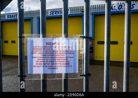 A notice on a garage informing customers that it is closed due to an outbreak of Covid-19 in the family which owns the business, Ashbourne, Derbyshire Stock Photo