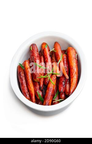 Grilled  baby carrots with honey sauce and green herbs isolated on white Stock Photo
