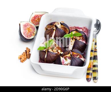 Baked  figs with goat cheese and walnuts with honey isolated on white Stock Photo