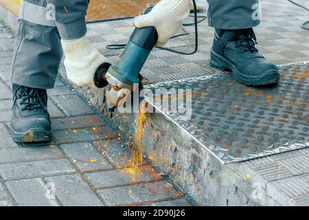 Processing of metal sheet with an angle-grinding tool Stock Photo