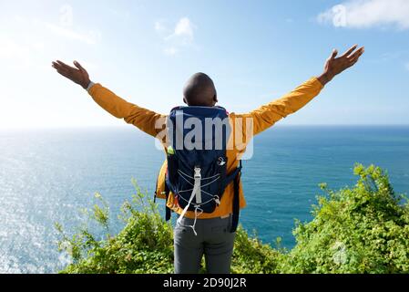 Portrait from behind of male hiker with arms outstretched Stock Photo