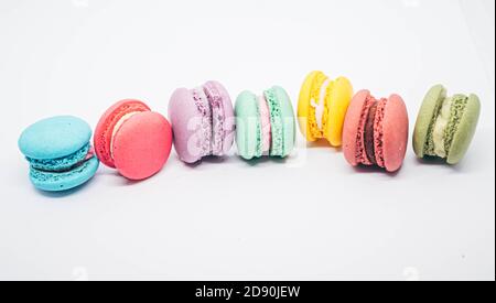 Pastel colored macarons sweet French dessert isolated on white background. Stock Photo