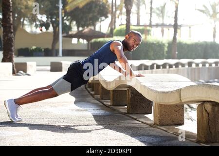 Portrait of healthy young man doing pushups outdoors Stock Photo