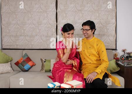 Indian couple with sweets and gifts while celebrating Diwali, Deepavali or Dipavali festival. Stock Photo