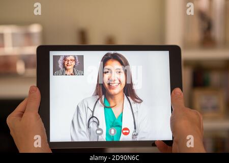 elderly woman having video call consultation with doctor on tablet Stock Photo