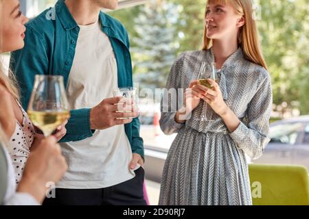 cropped photo of people enjoying time outdoors in cafe, they have talk, drink white wine Stock Photo