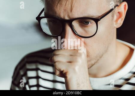 Tired pensive man deeply thinking at home. Winter depression. Seasonal affective disorder, anxiety, mental health, psychology. Unhappy man has family Stock Photo