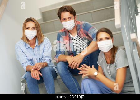 Couple of students wearing masks relaxing in the campus Stock Photo